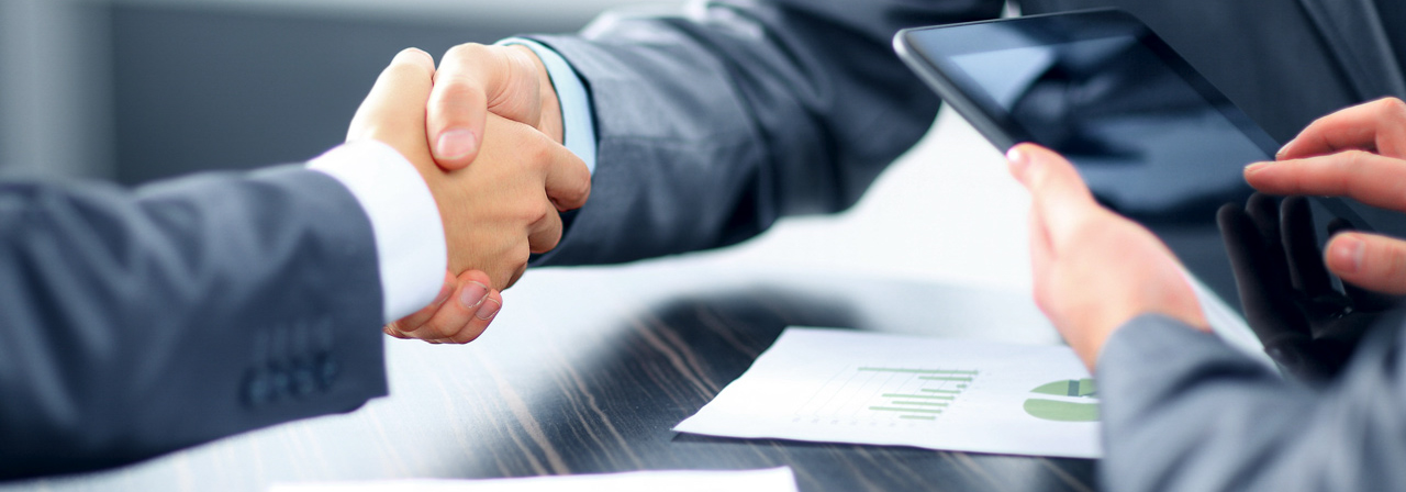 Vakanzüberbrückung und Führungsunterstützung. Handshake zwischen zwei Managern – Symbol für Vakanzüberbrückung, Führung auf Zeit und operative Führungsunterstützung