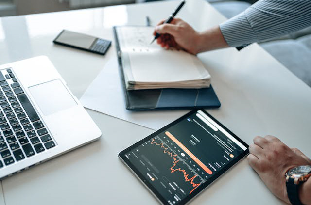 ertriebssteuerung und Channel Excellence. Manager analysiert Vertriebszahlen und macht Notizen im Filofax – Symbol für Vertriebssteuerung, Channel Excellence und Sales-Optimierung